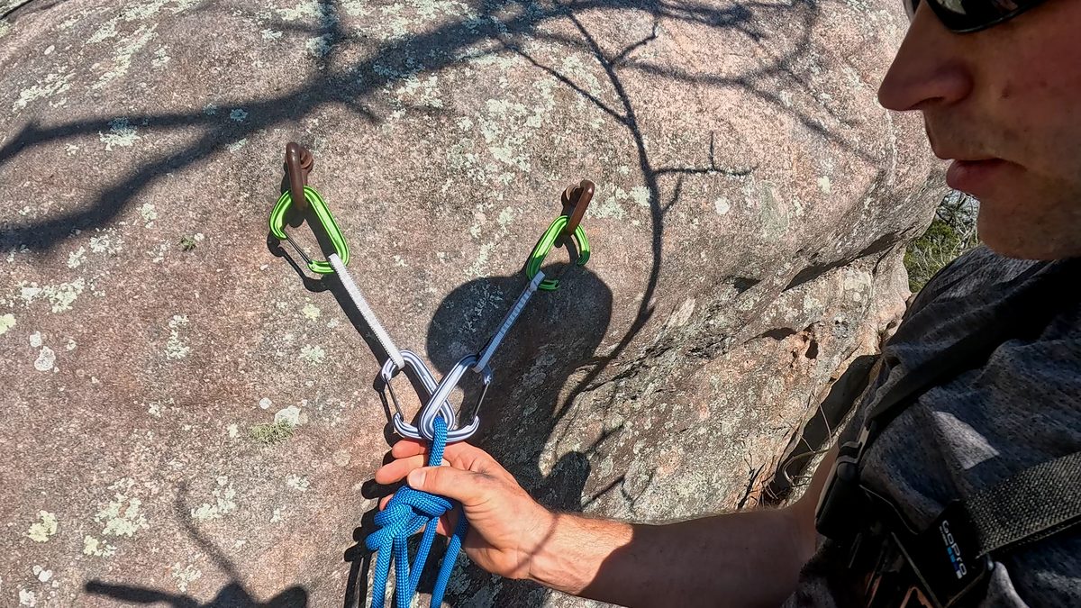 Man building anchor with quickdraws