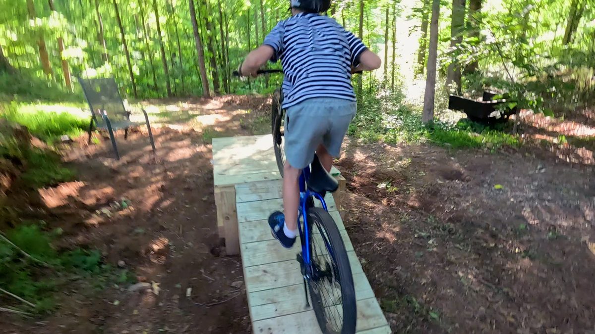 Boy jumps over table top jump ramp