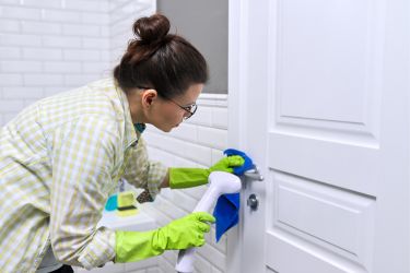 Woman steam cleaning her door