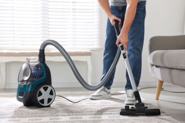 Man vacuuming the carpet