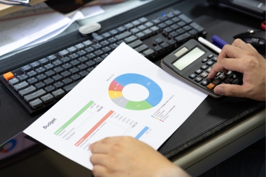 Man looking at the budget and using a calculator