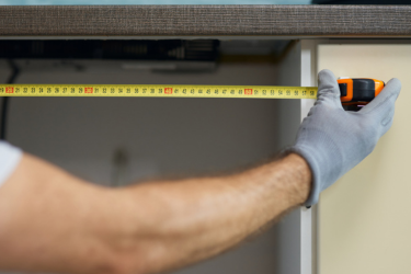 Man measuring cabinets