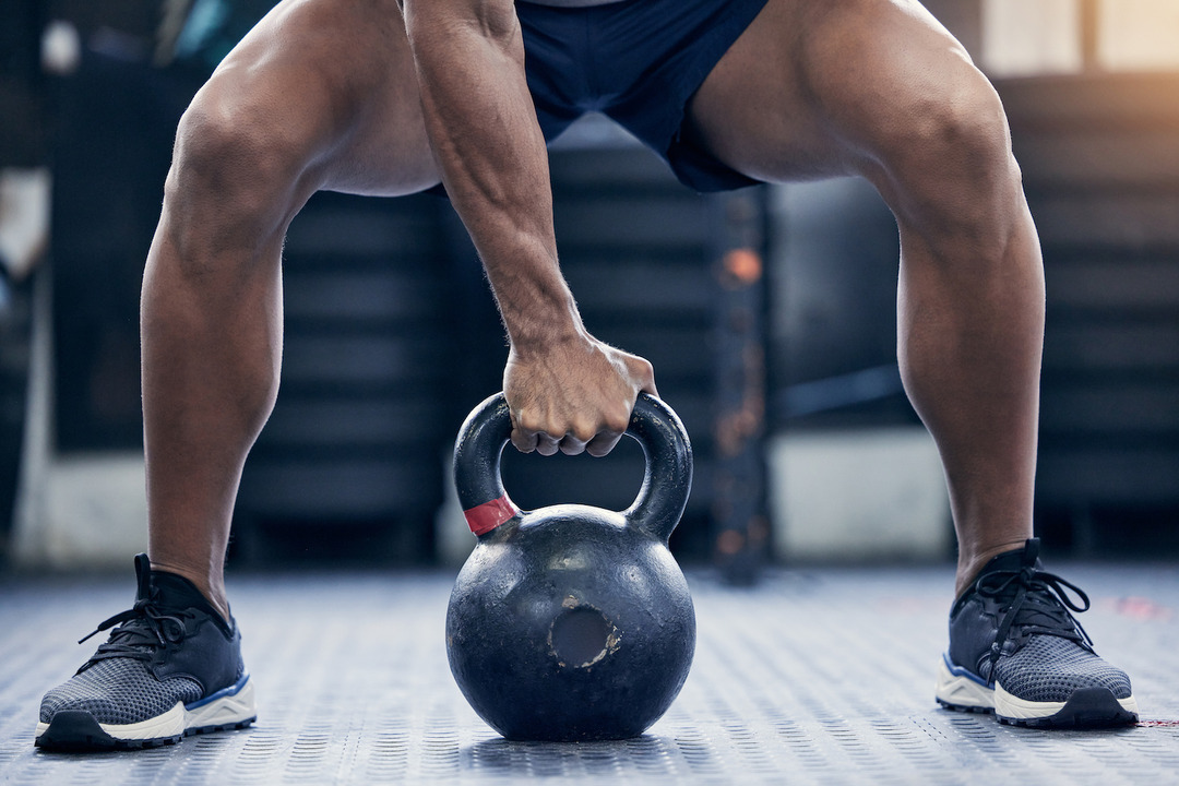 man holding a kettlebell - Grip Strength Norms