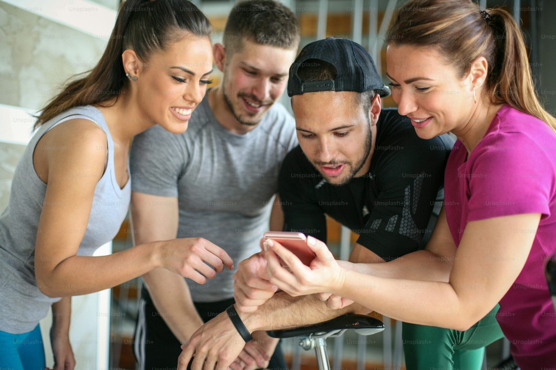 people looking at a phone - Best Workout Tracker App