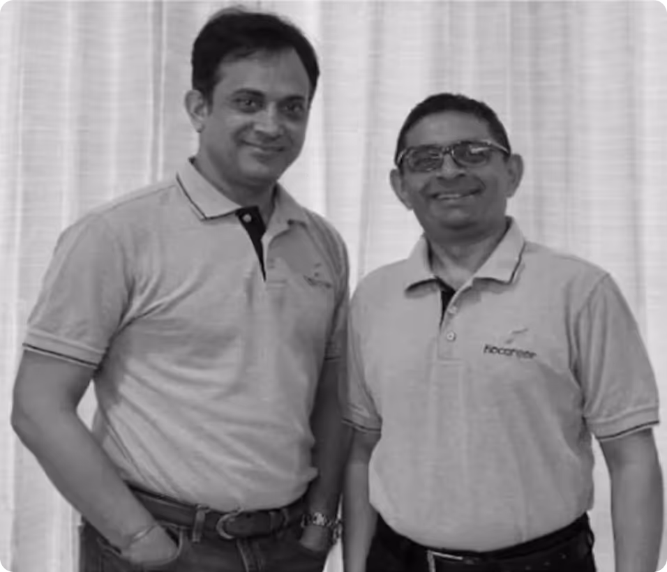 Two men smiling, wearing short-sleeve polo shirts and standing in front of a curtain backdrop.