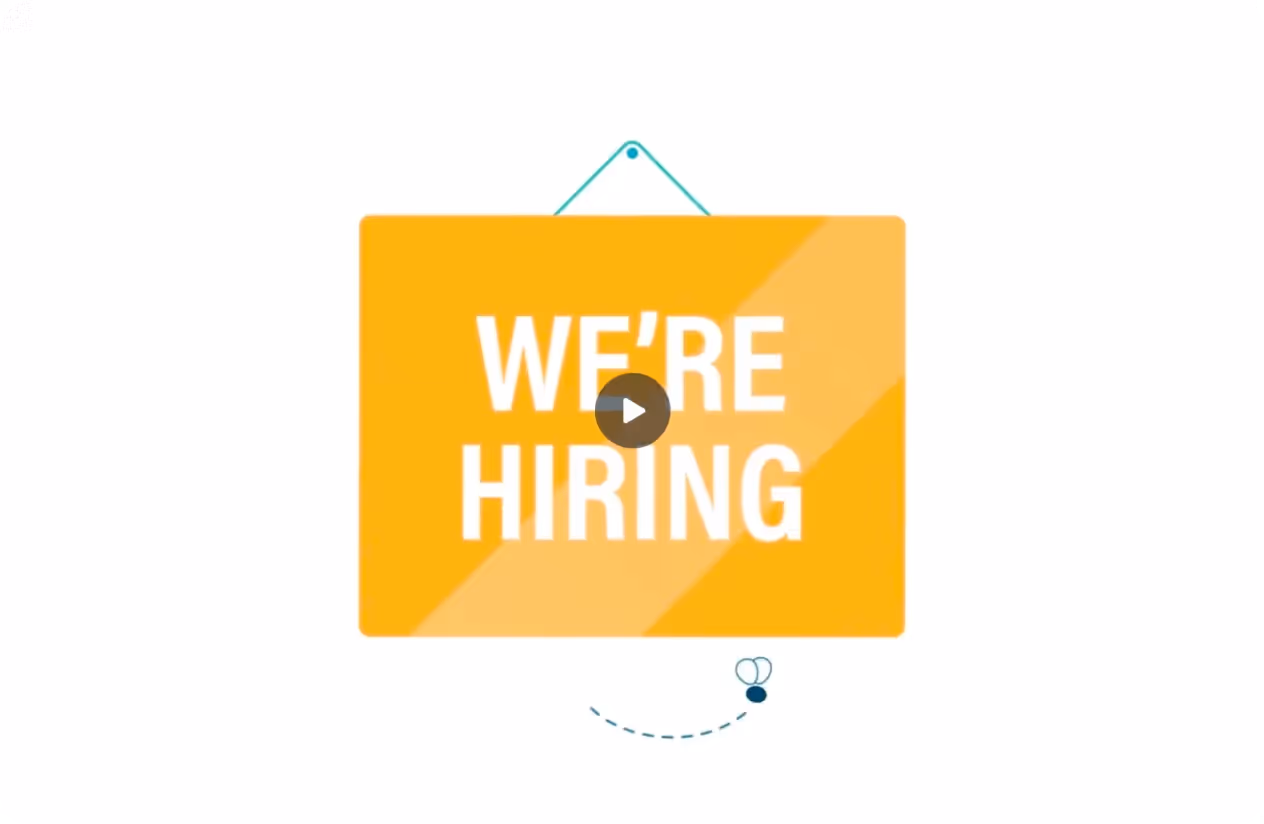 Yellow sign with white text reading 'WE'RE HIRING' hanging against a white background.
