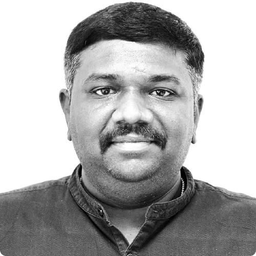 Close-up black and white portrait of a man with short hair, mustache, and a collared shirt.