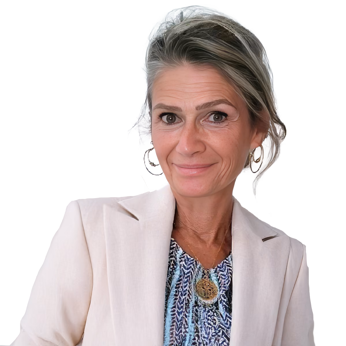 Woman with gray hair in a white blazer and patterned top smiling at the camera.