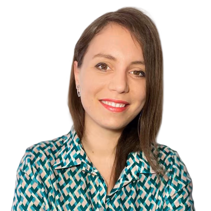 Smiling woman with straight brown hair wearing a geometric patterned shirt against a plain background.