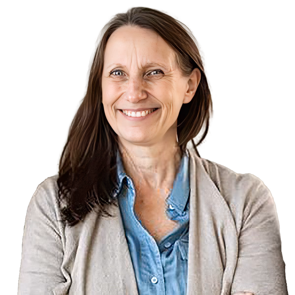 Smiling woman with long brown hair wearing a blue shirt and beige cardigan on gray background.