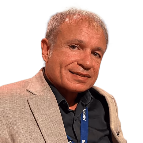 Man with gray hair wearing a beige blazer and black shirt with an Airbus lanyard.