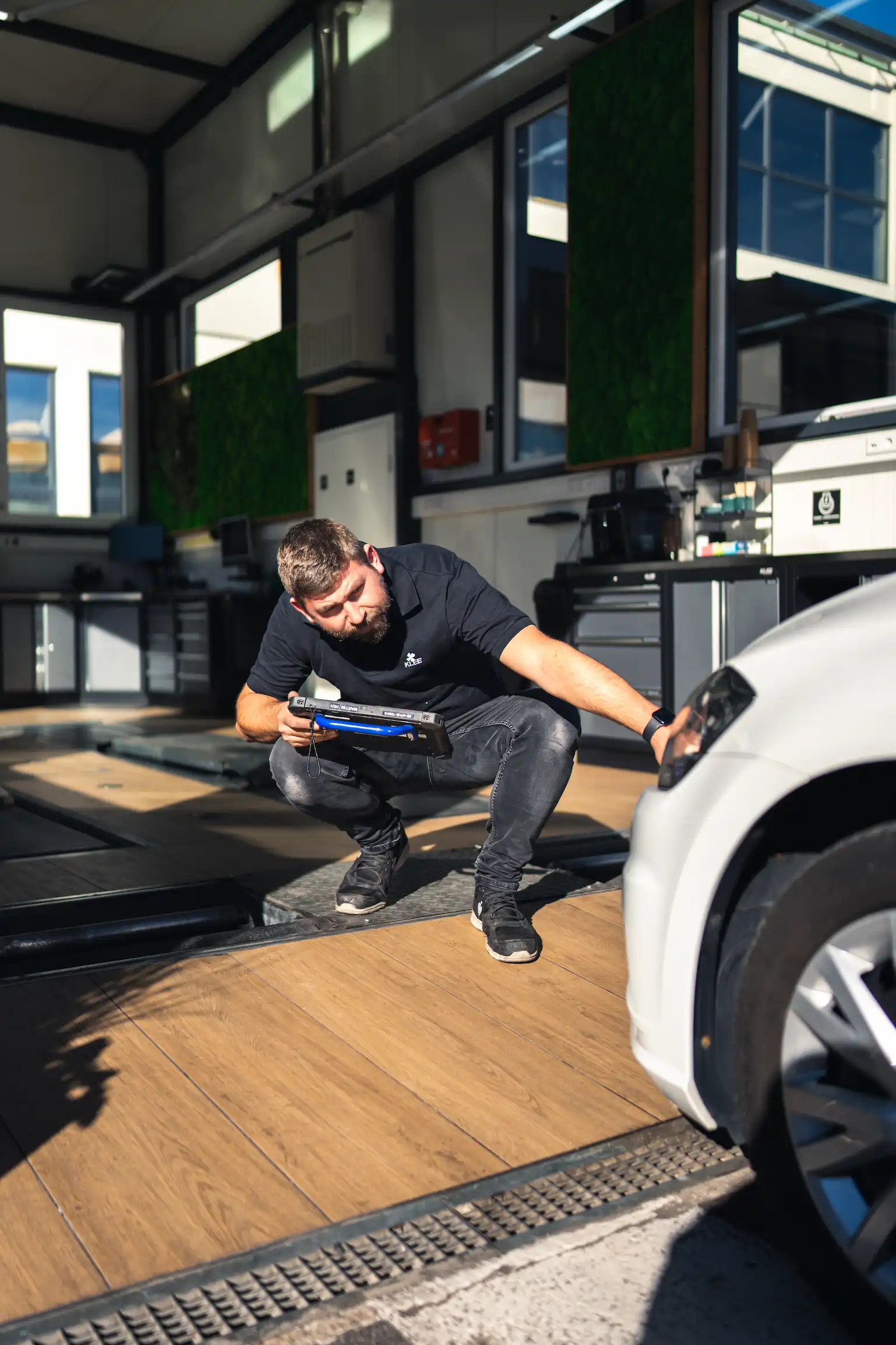 Martin von KLEE-sicher führt vor dem Fahrzeug eine Sichtprüfung im Rahmen der Hauptuntersuchung (HU) in Stuttgart-Sommerrain durch.