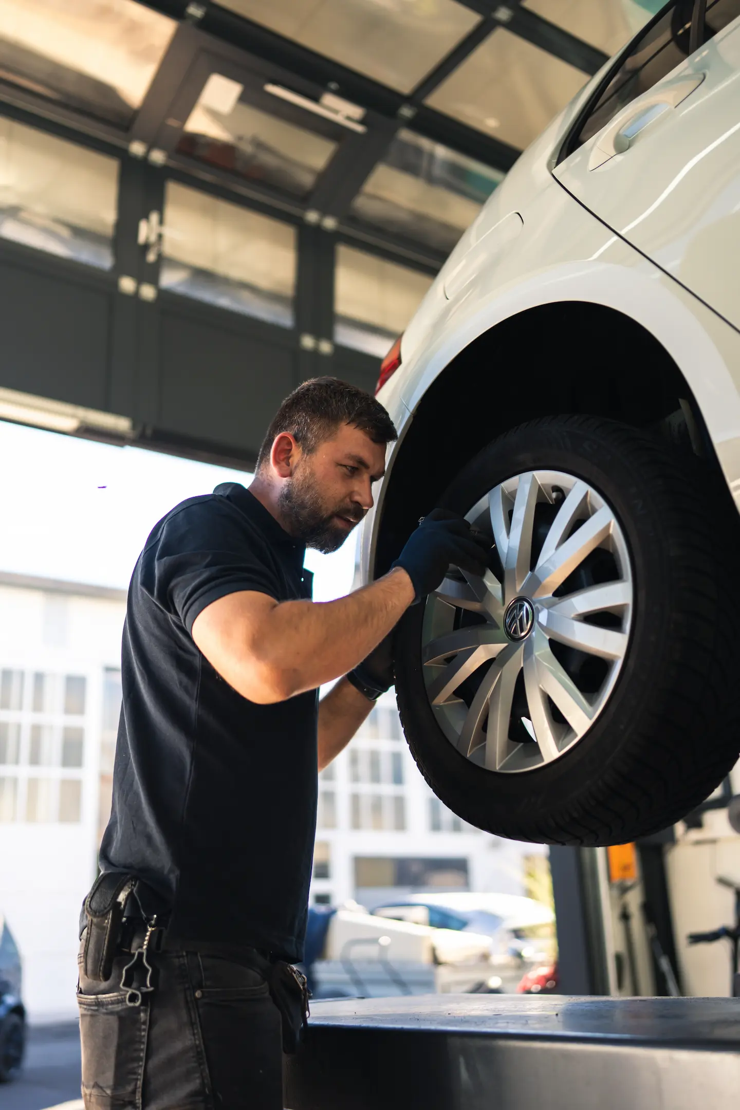 Martin von KLEE-sicher prüft ein Fahrzeug auf der Hebebühne im Rahmen der Hauptuntersuchung und Abgasuntersuchung (HU/AU) – präzise TÜV Prüfung für Deine Sicherheit.