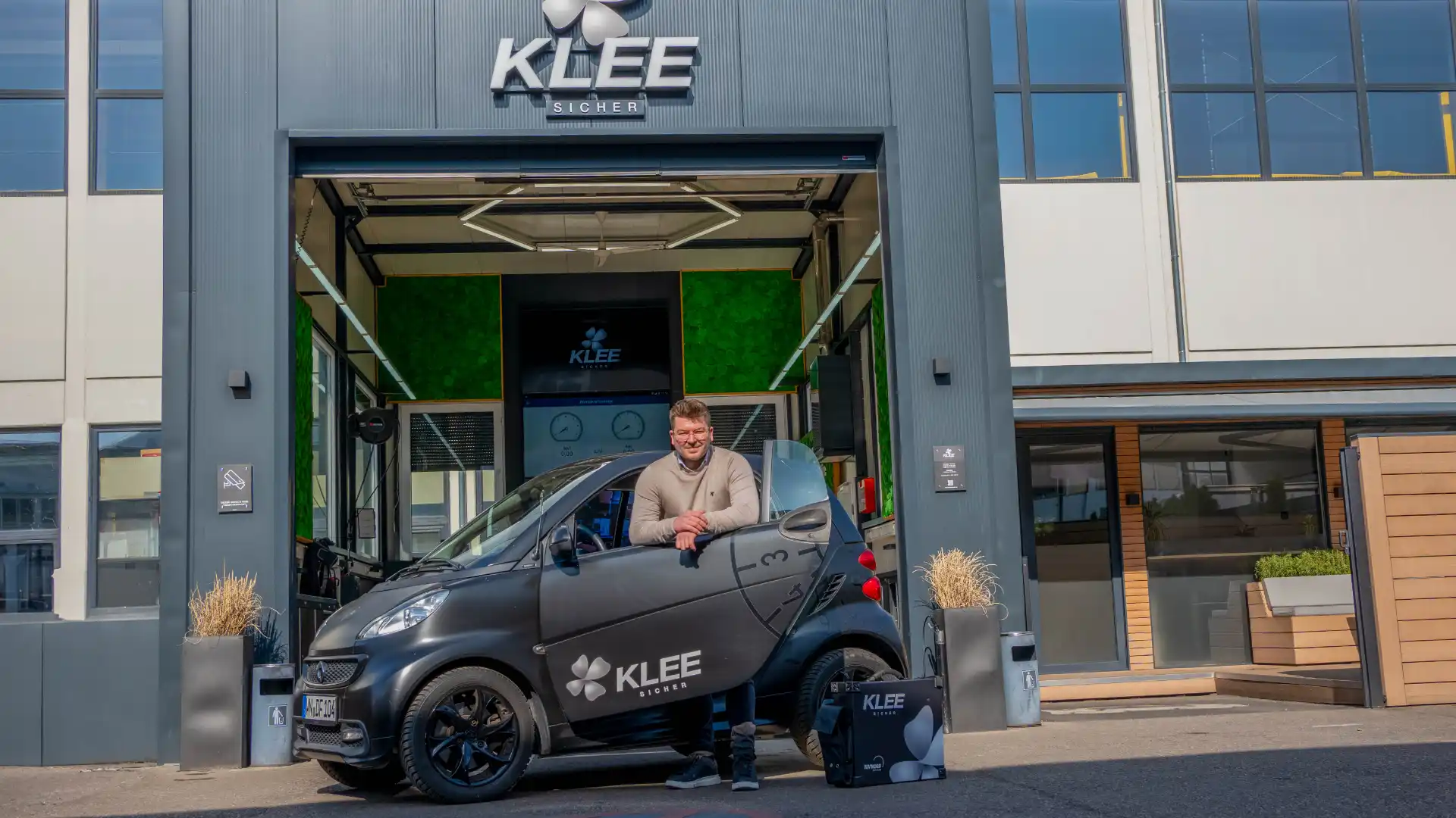 Dennis von KLEE-sicher begrüßt dich vor unserer TÜV Prüfstelle in Stuttgart-Sommerrain – dein TÜV Nord Partner vor Ort.