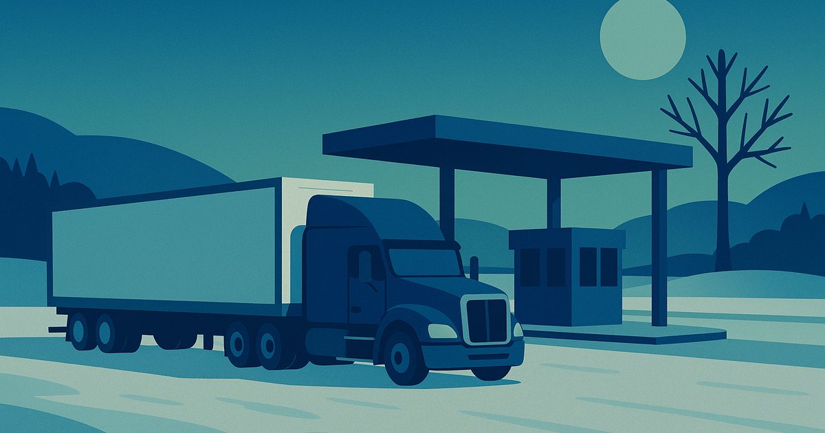 A semi truck waiting at a snowy Canada-U.S. border crossing at dusk