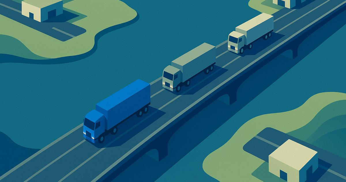 Three semi trucks approaching an international bridge over a river, seen from above, with one truck picked out in blue