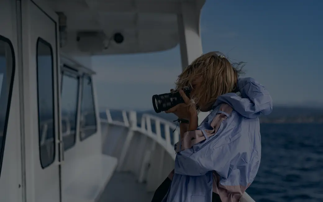 woman taking a picture of the ocean from a boat