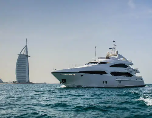 yacht in the middle of the ocean with a burj al arab in the