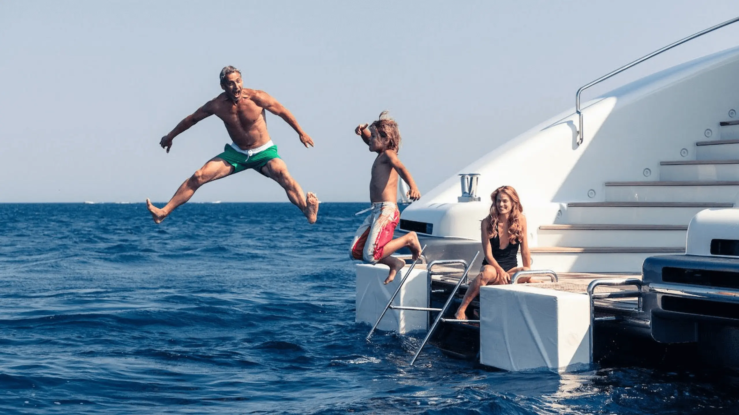 there are two people jumping off a boat into the water