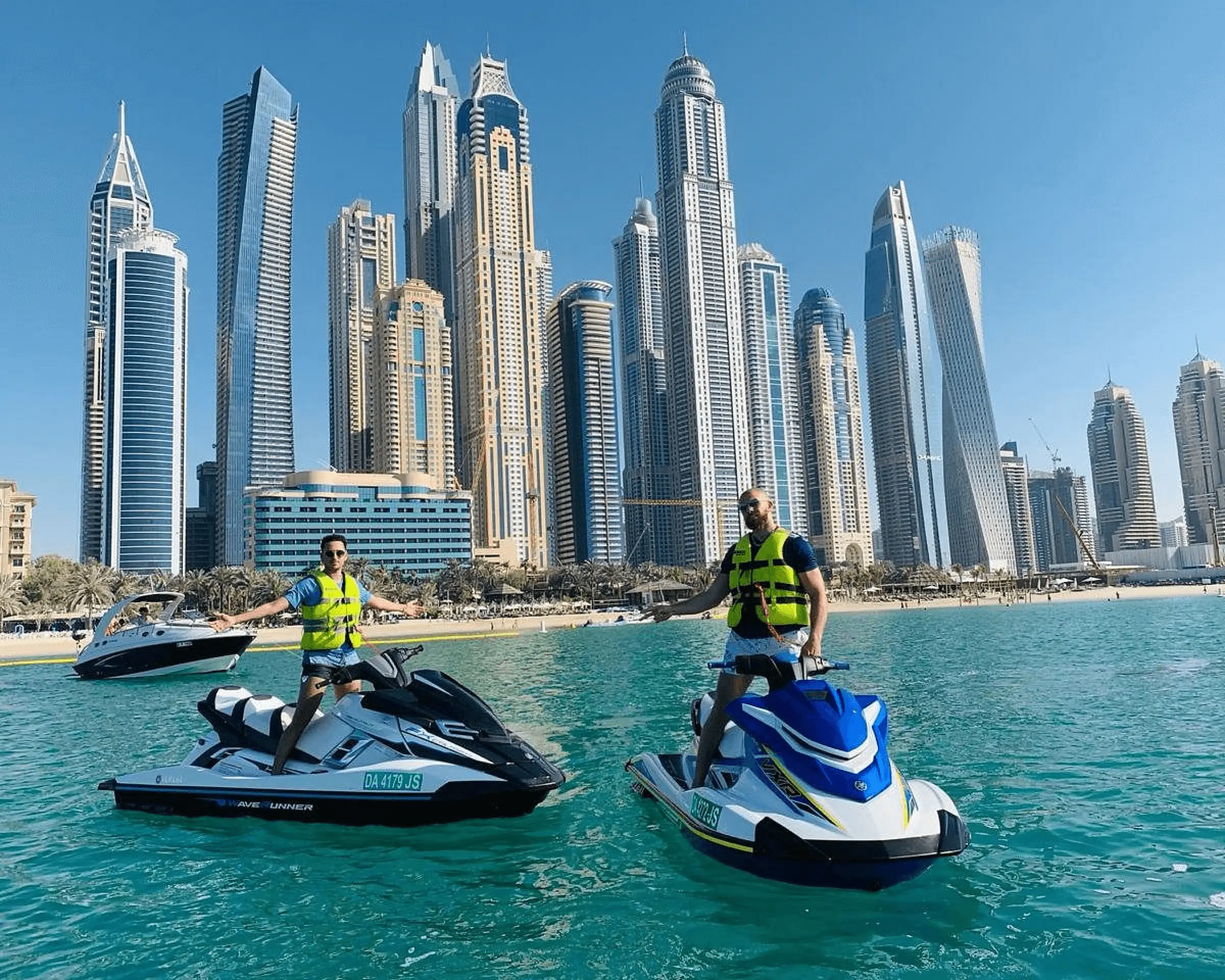 two men on jet skis in the water in front of a city