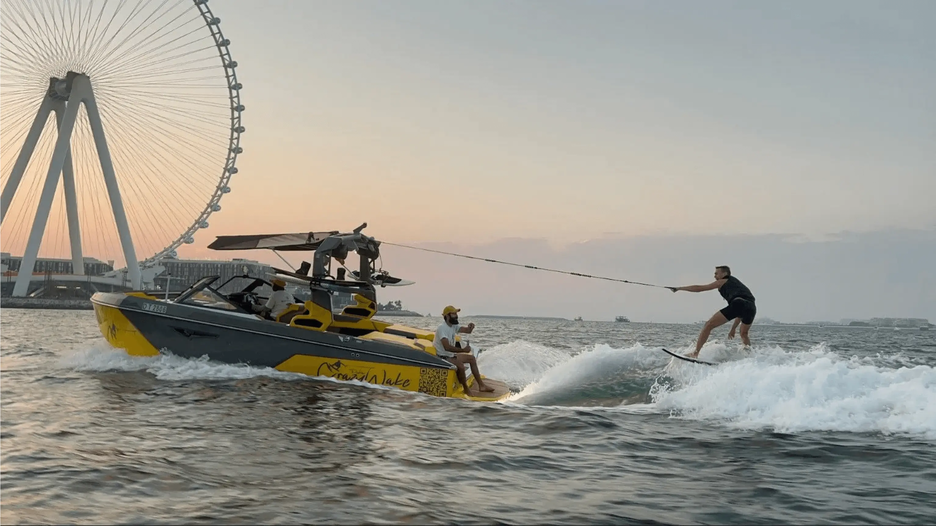 surfers are riding on the waves in front of a ferris wheel