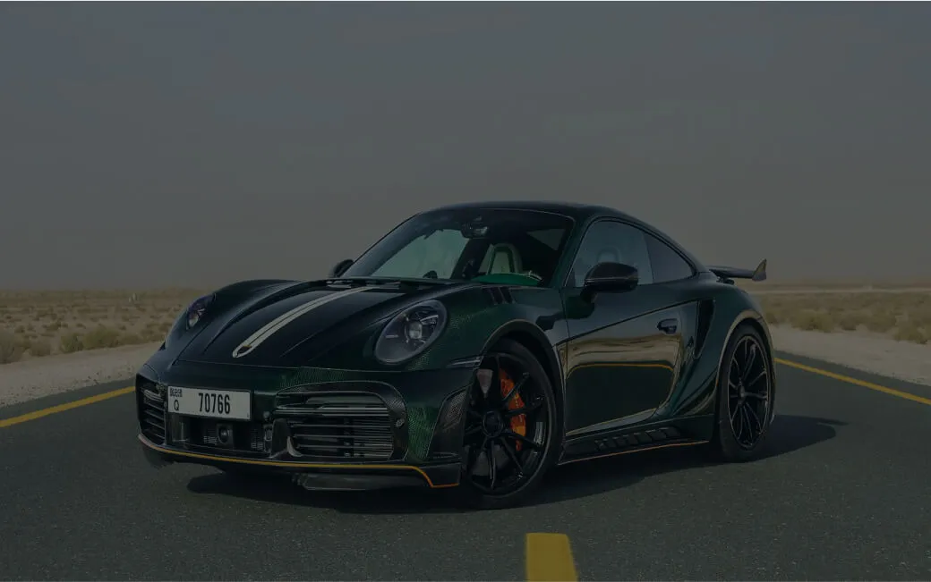 a green porsche 911 gts driving down a desert road
