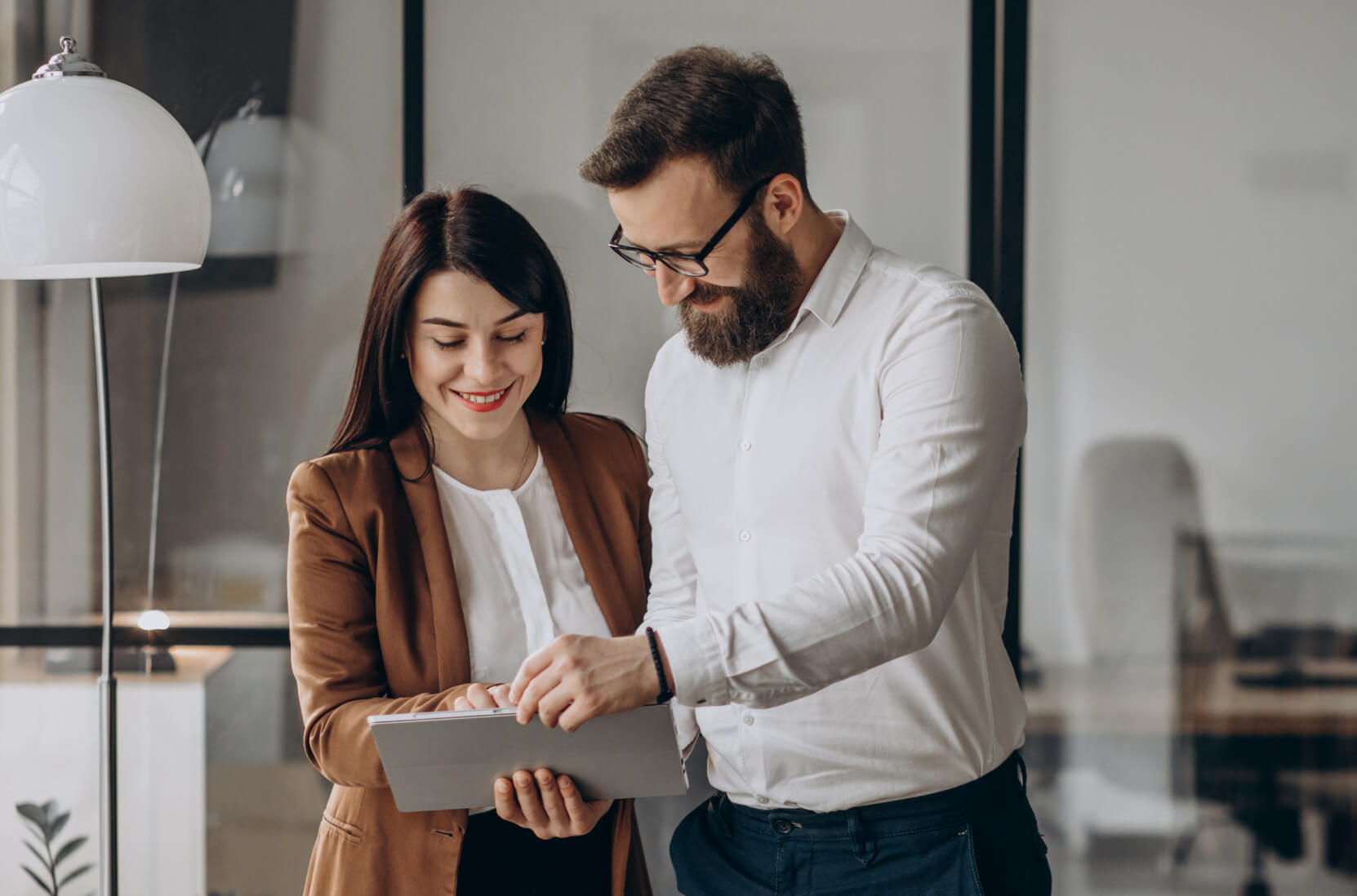 A man and a woman looking at a tablet.