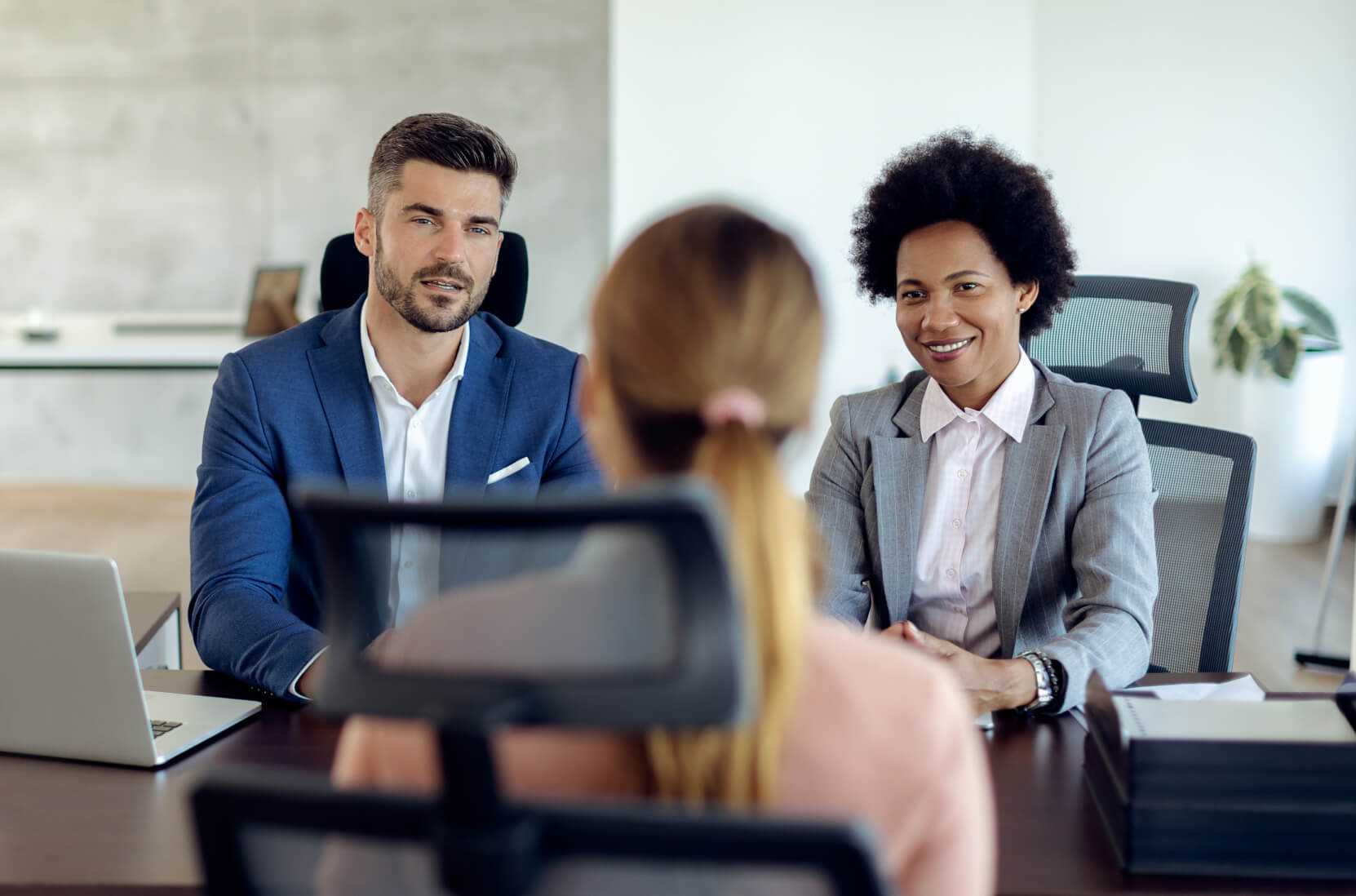 A group of people sitting around a wooden table.