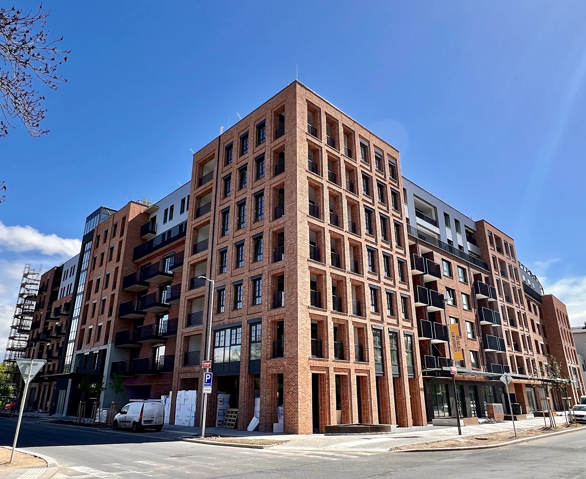 Nový moderní cihlový bytový dům se šesti patry a balkony za jasného slunného dne.