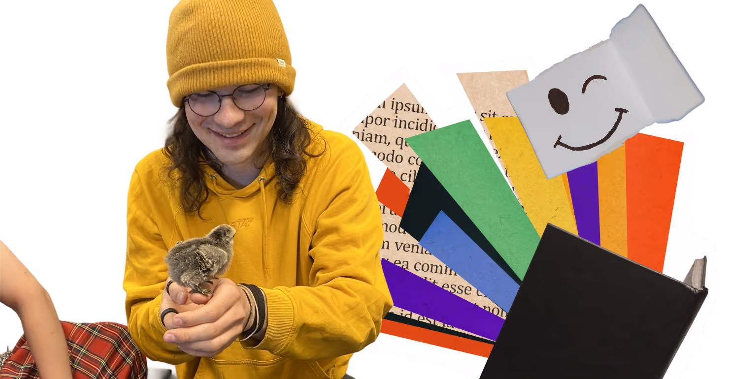 Person med gul lue og hettegenser som smiler mens de holder en liten kylling i hendene, med fargerike papirbiter og en bok i bakgrunnen.