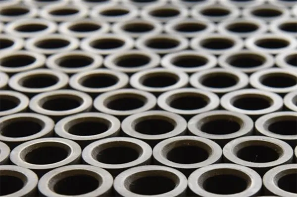 Nahaufnahme von vielen gleichmäßig angeordneten Metallringen mit dunklem Innenraum.
