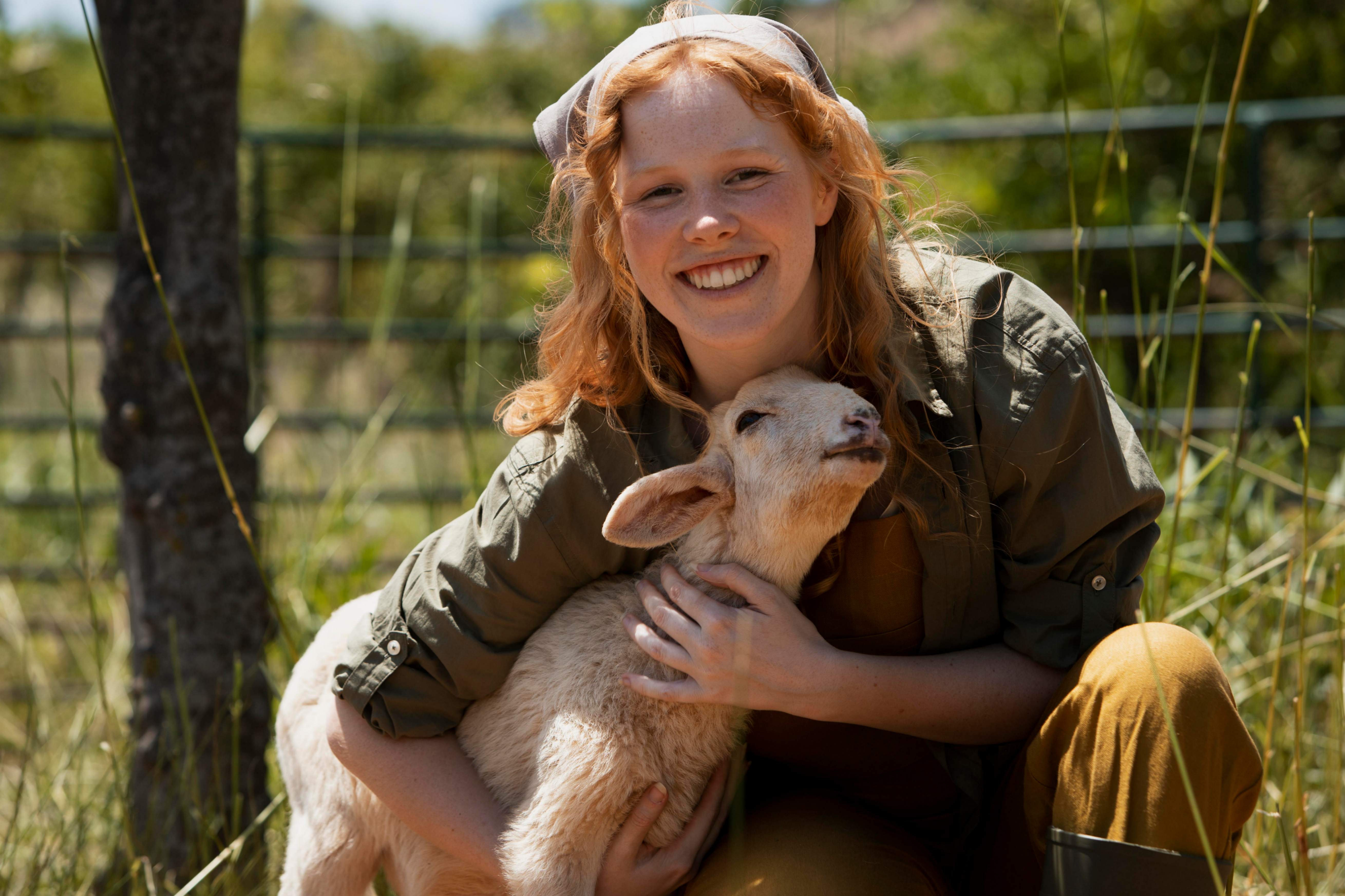 Une jeune femme fait un câlin à un petit agneaux