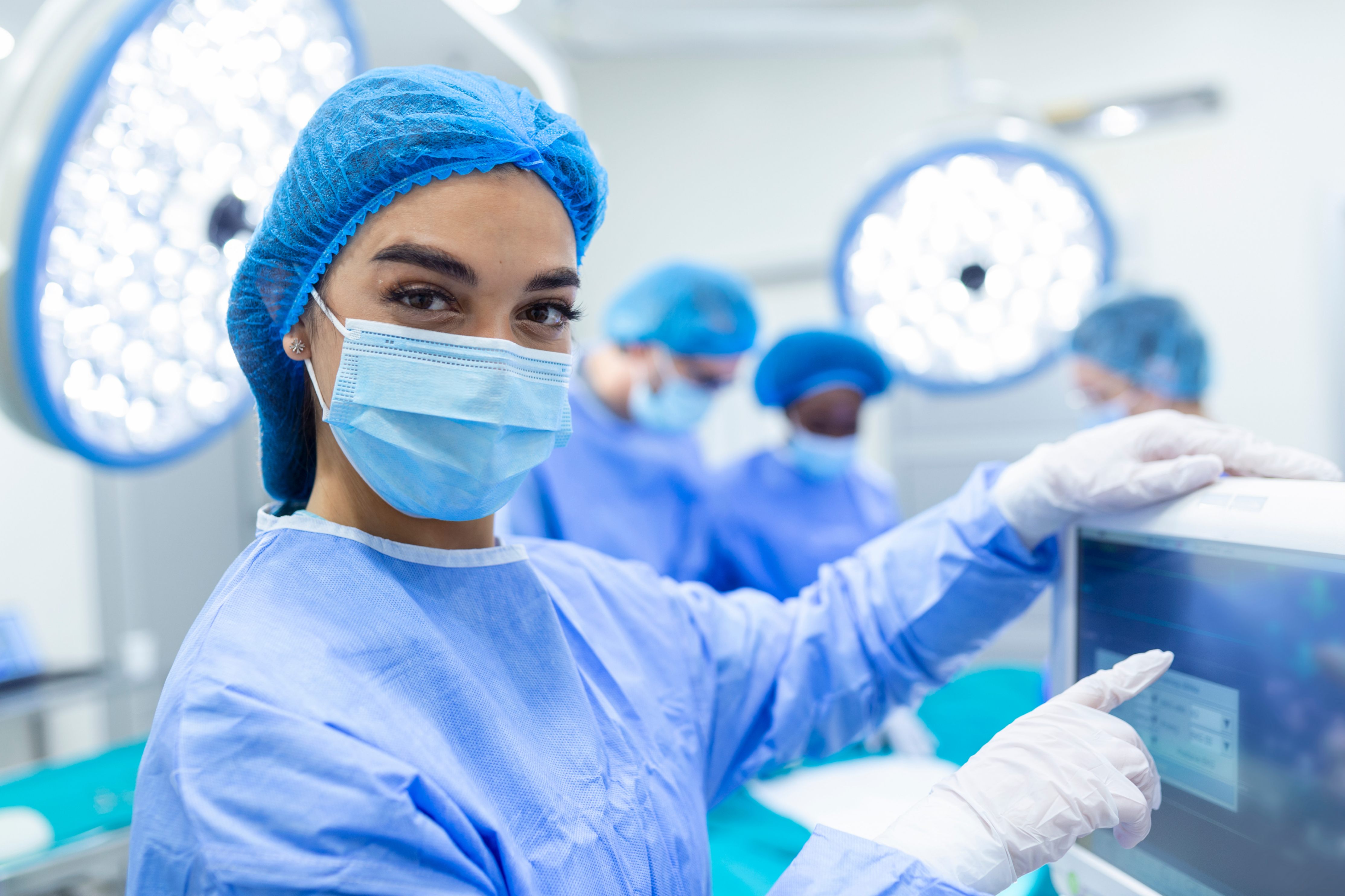 Une jeune chercheuses regarde vers l'objectif, elle porte un masque bleue