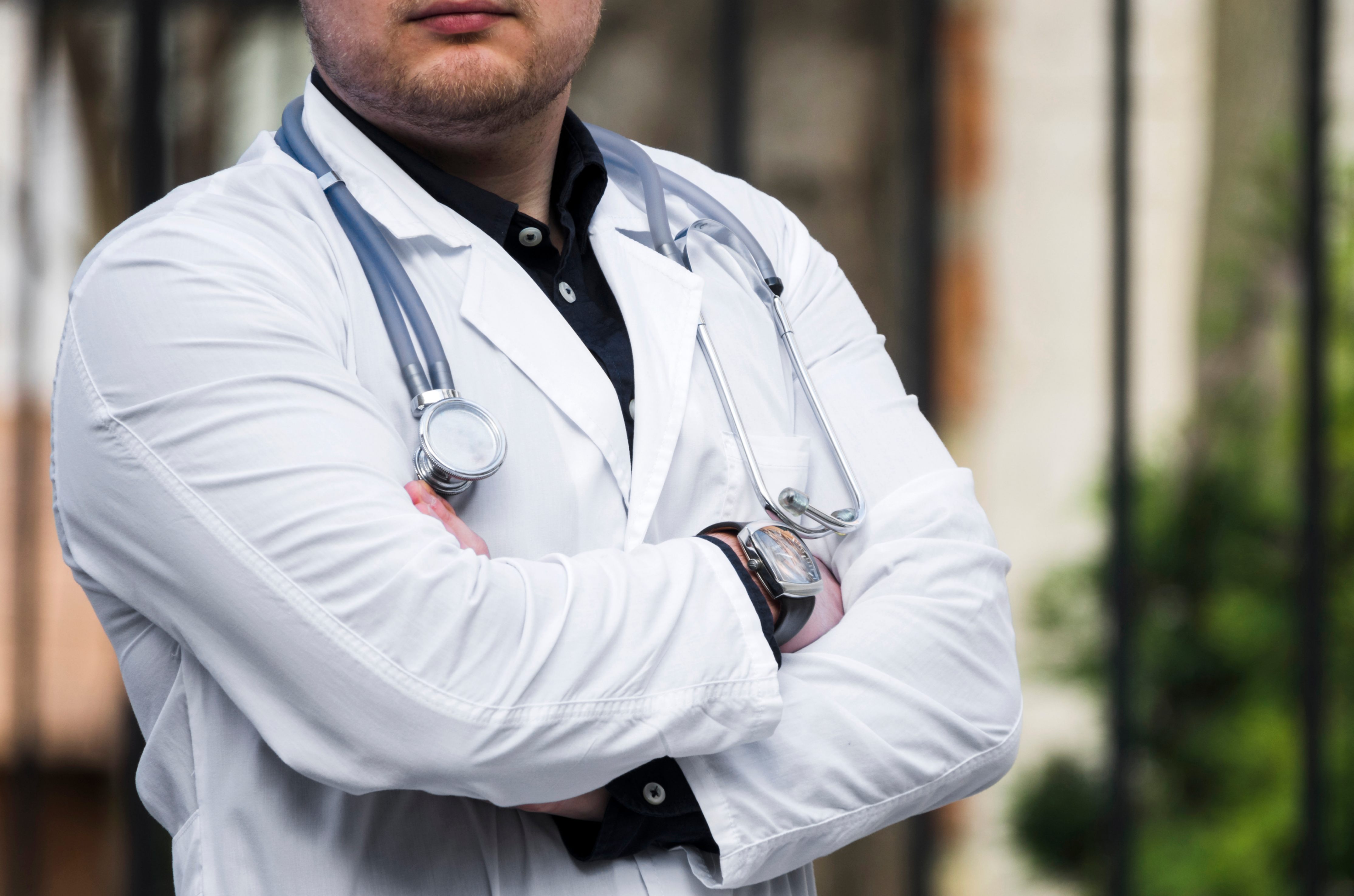 Un médecin tient les bras croisés, en position de réflection