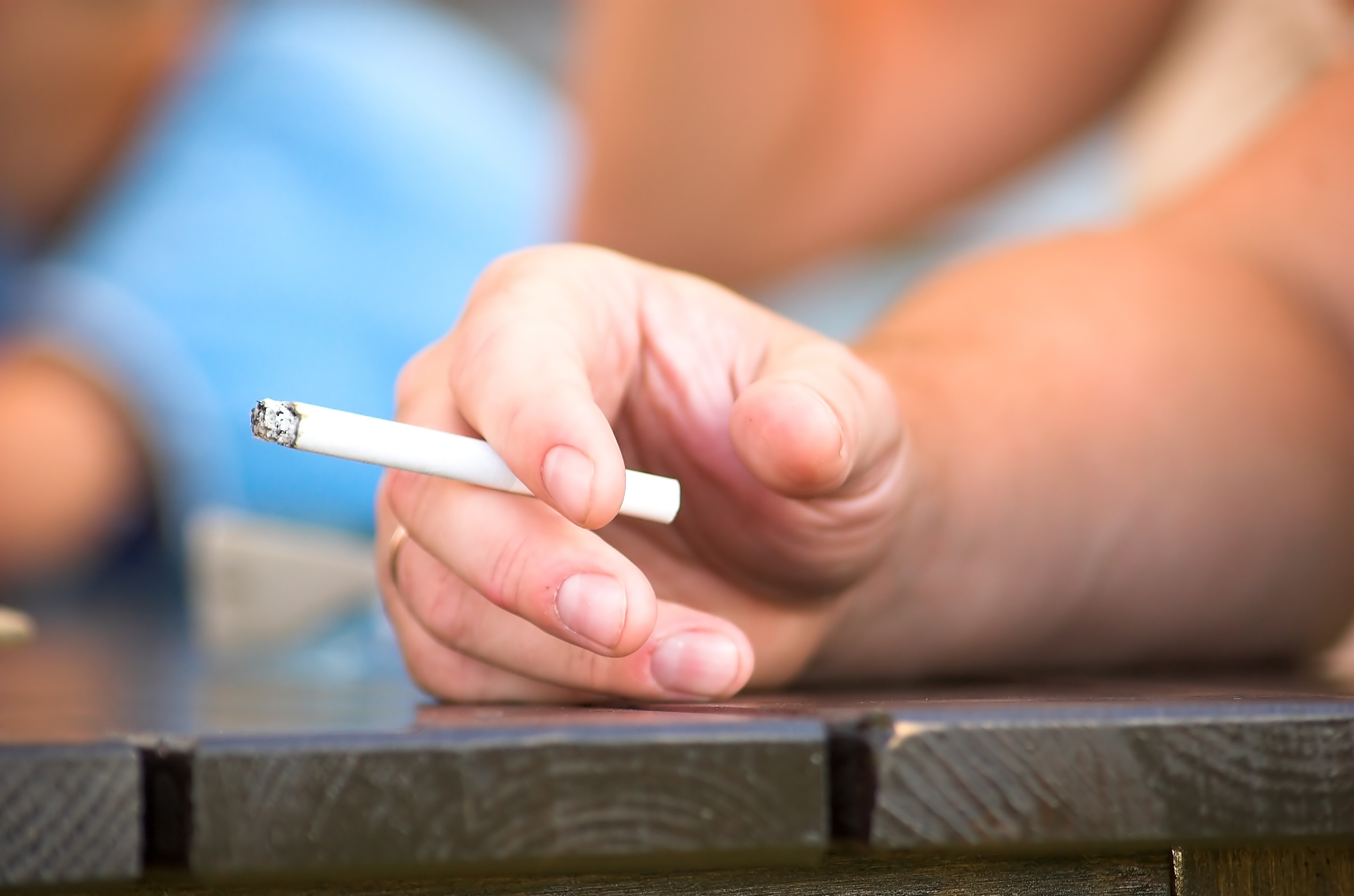 Une main tenant la cigarette de près