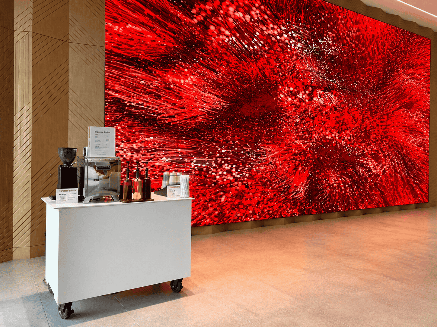 Espresso Station coffee cart beside a large red LED art wall in an office lobby