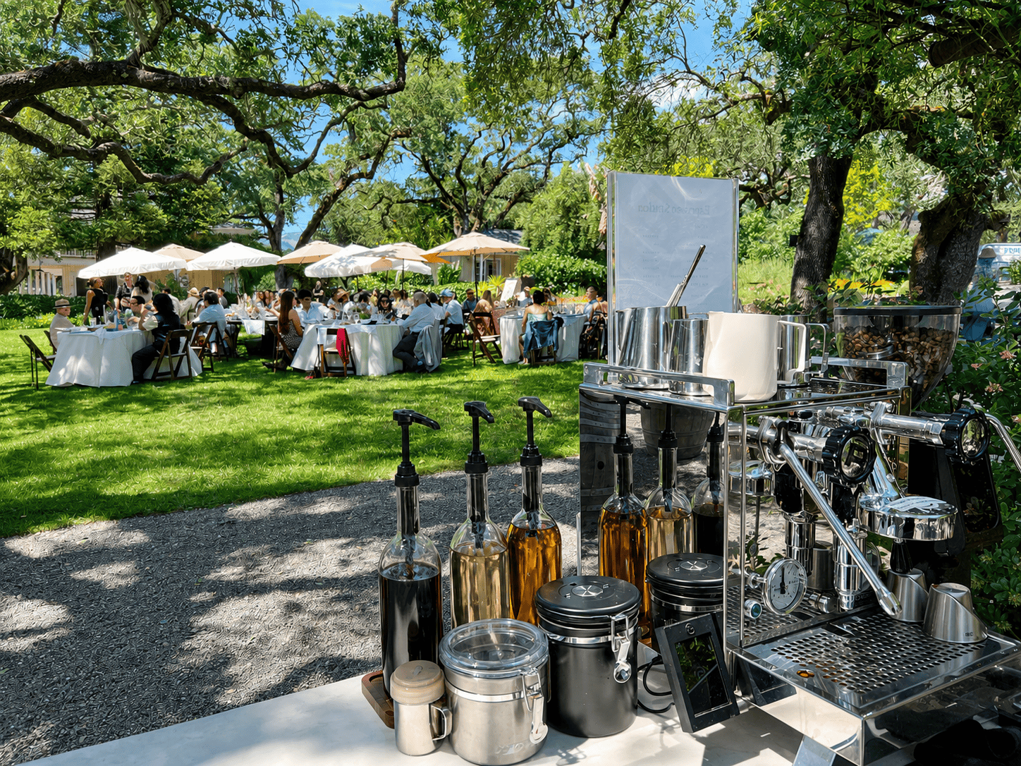Espresso Station coffee cart at a sunny garden luncheon, guests seated under oak trees