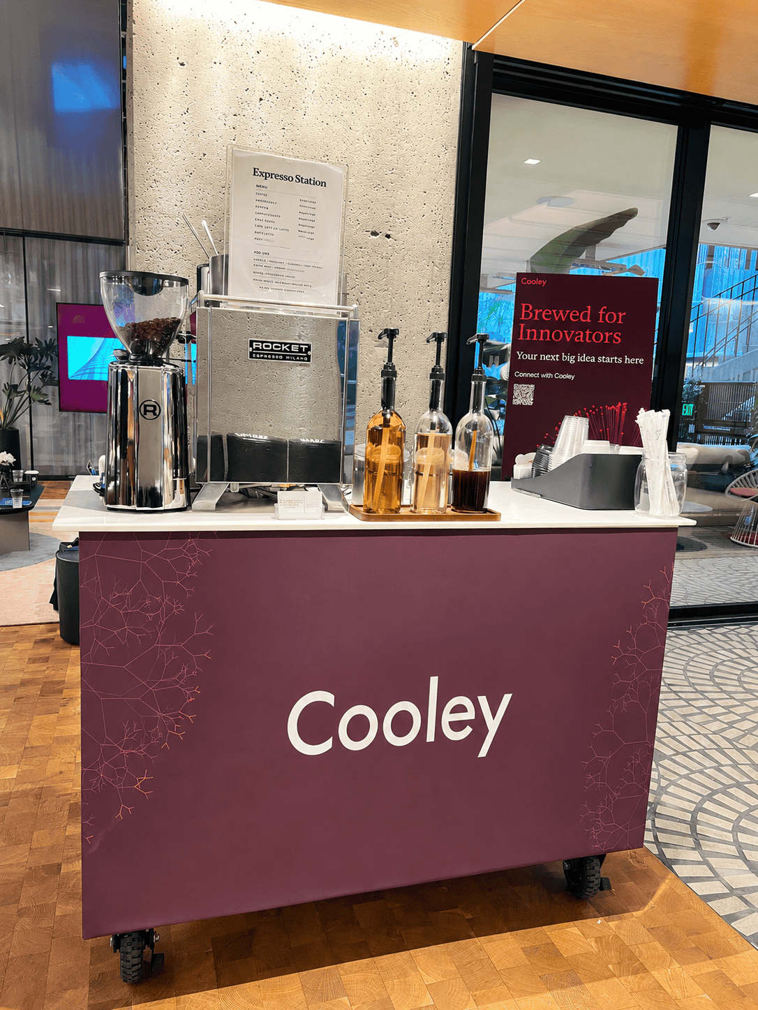Espresso Station coffee cart branded with the Cooley law firm logo at a corporate event