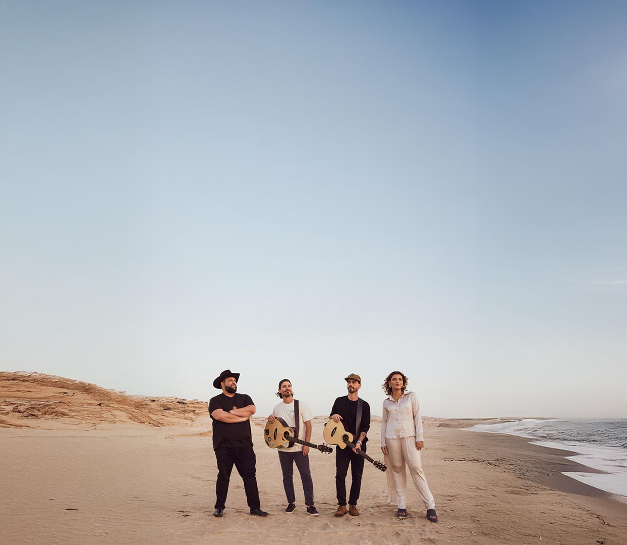Bob and Clint Moffatt on a beach singing with other collaborator.