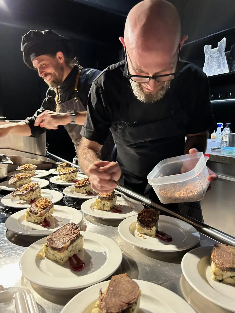 Kuchař připravuje signature menu během gastronomické show na partnerském setkání SULKO.