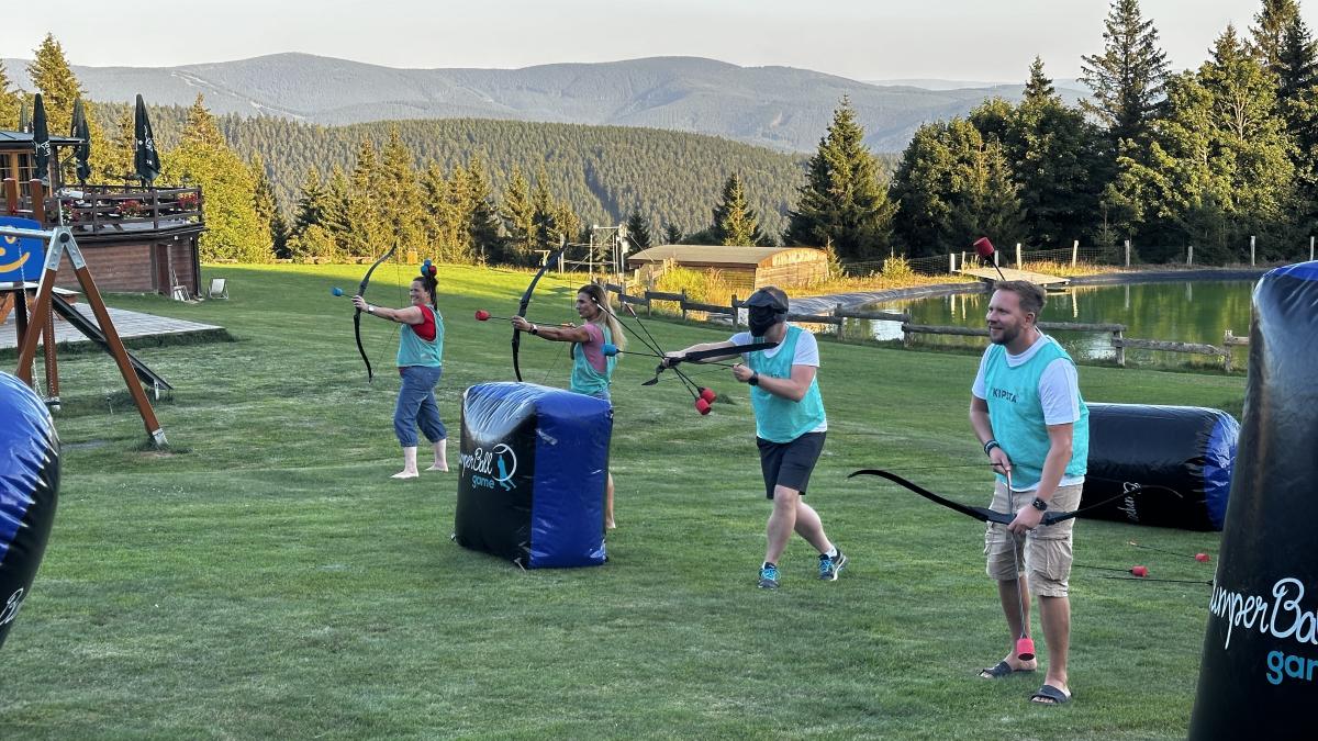 Zaměstnanci SULKO během teambuildingové aktivity archery game na louce.
