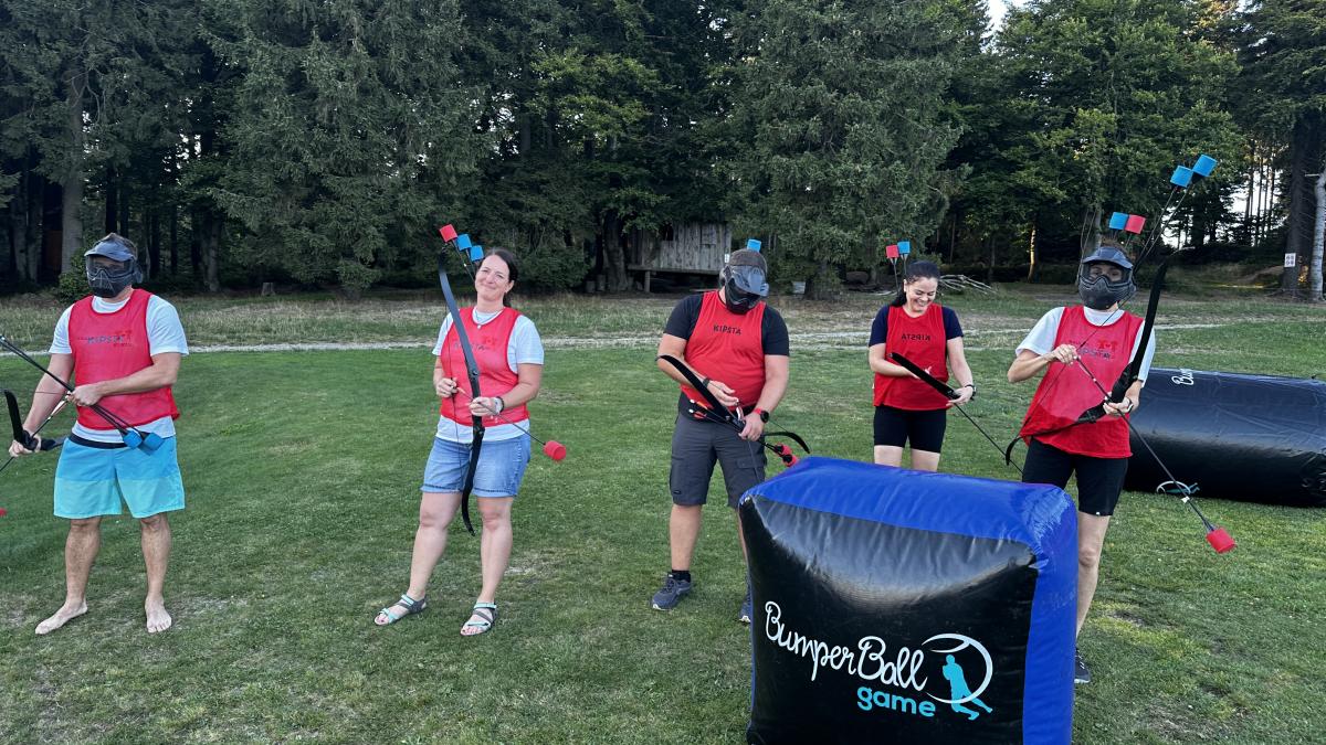 Zaměstnanci SULKO během teambuildingové aktivity archery game na louce.