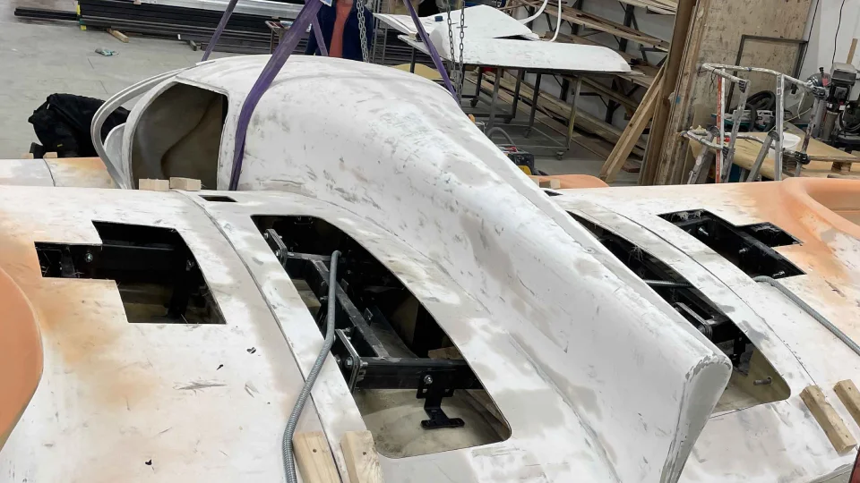 Engineers assembling the fuselage of a Doroni aircraft prototype in a workshop.