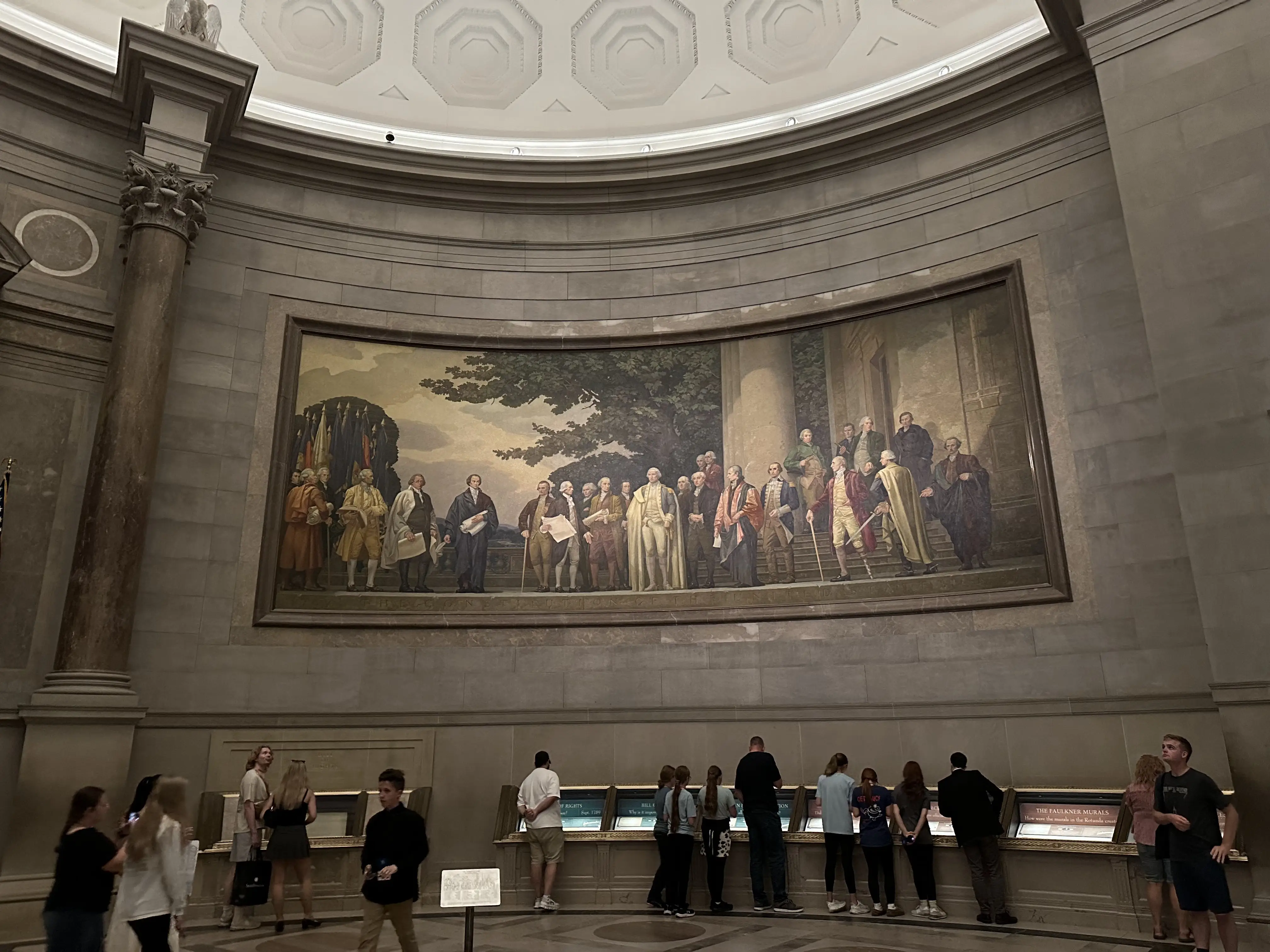 Couple standing among stunning rock formations with colorful hot air balloons filling the sky during sunrise or sunset
