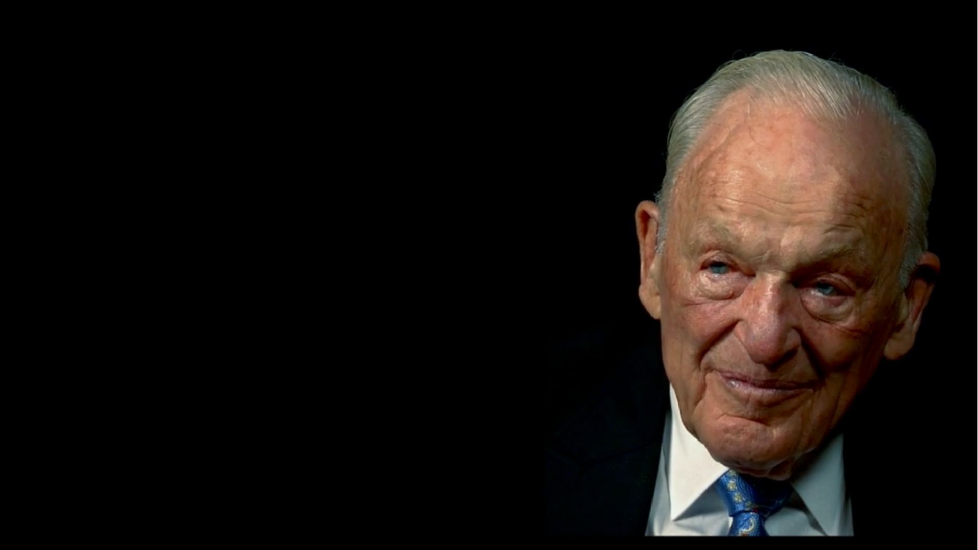 Marshall Bennett in suit and black background 