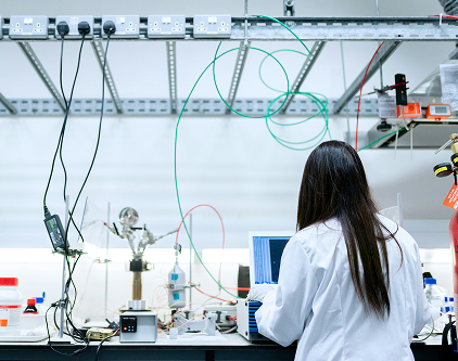 A female scientist with dark hair working in a lab.