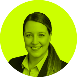 Smiling woman with long hair tied back, wearing a suit jacket and collared shirt, against a circular bright green background.