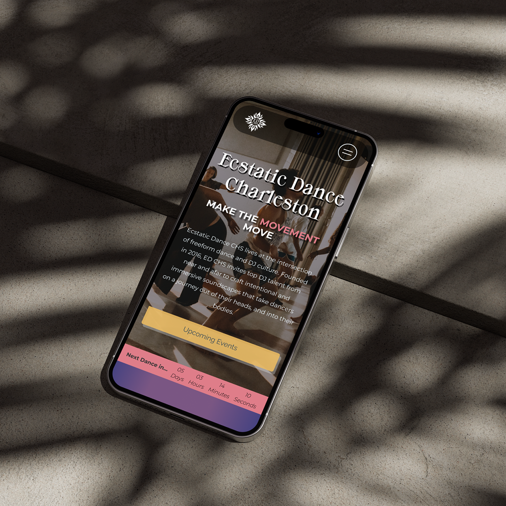 Smartphone on concrete surface displays Ecstatic Dance Charleston website with event countdown and upcoming events button.