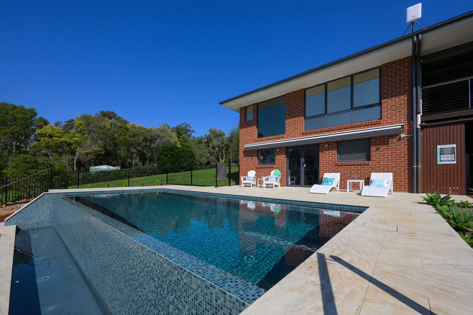 A large house and a blue water swimming pool perfect for outdoor activity.