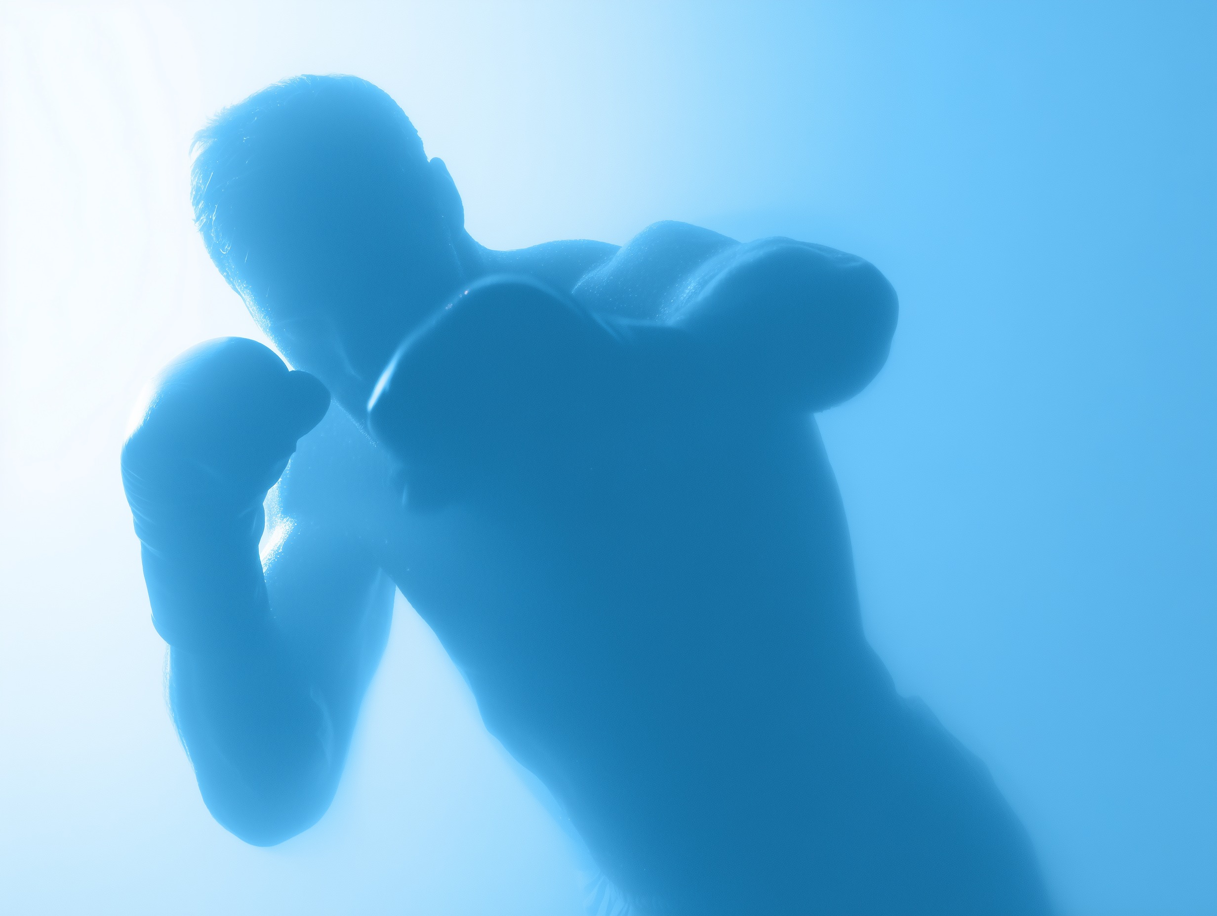 Boxer wearing gloves in a fighting stance with glowing blue lighting.